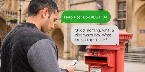 A man texting with a post box